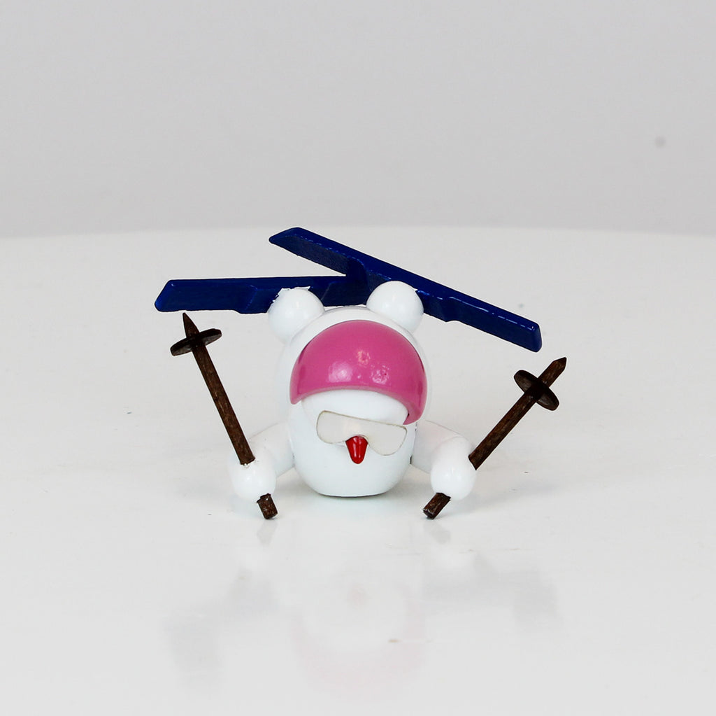 Schneemann mit Ski und rosa Helm